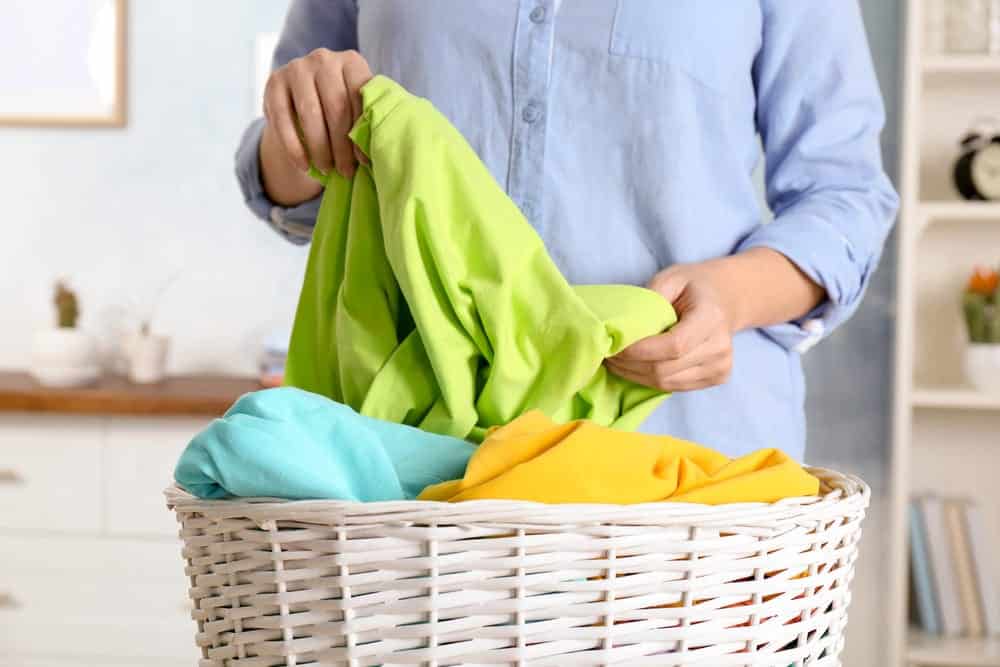 Close-up of woman sorting brightly colored laundry in basket