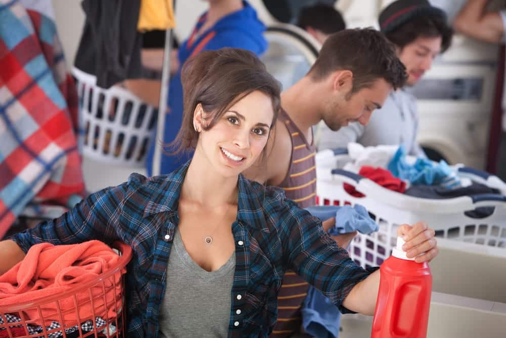Smiling woman in a busy laundromat