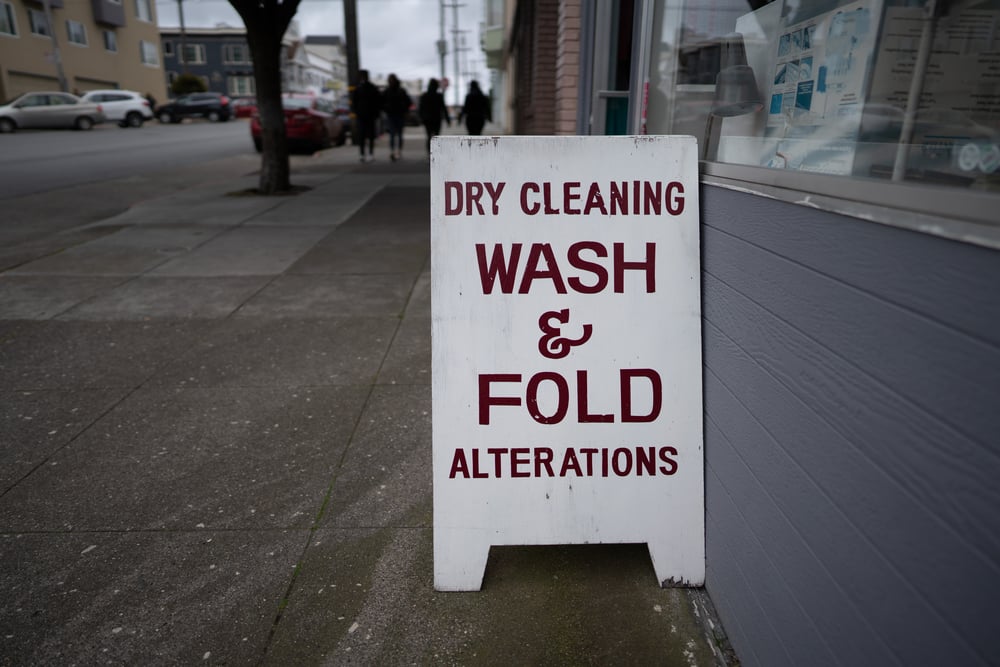sign outside shop reading "dry cleaning, wash & fold, alterations"
