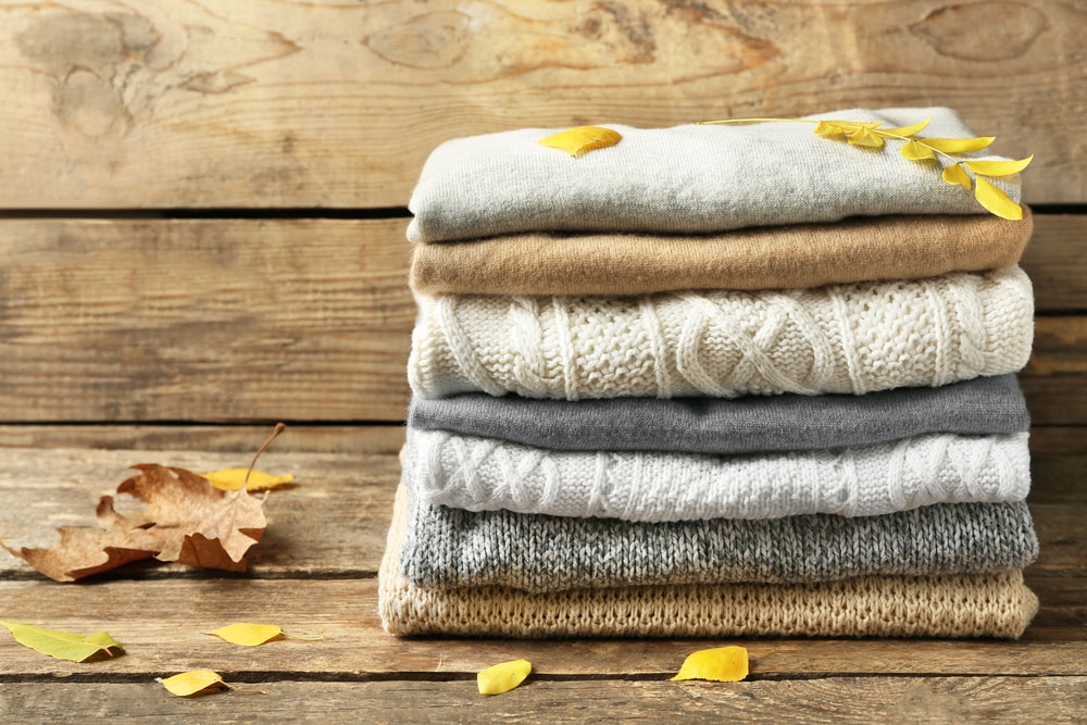 Stack of folded clothes with autumn leaves