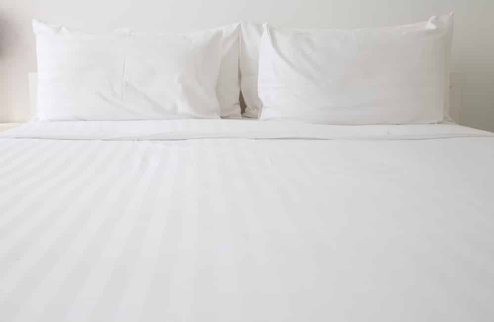 clean white sheets and pillows on bed