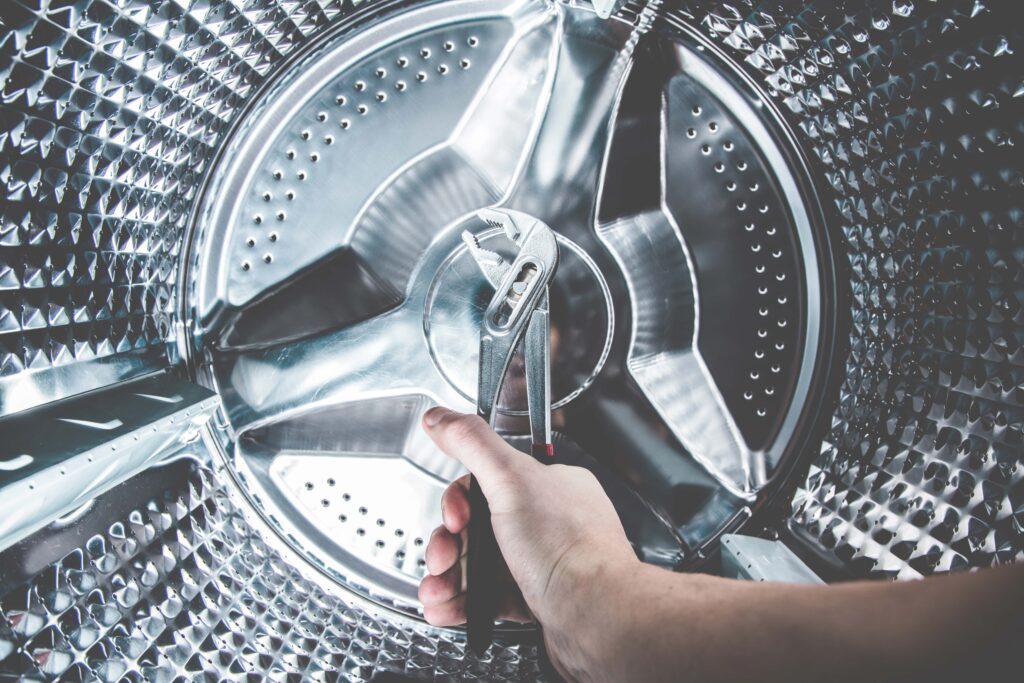 hand holding wrench in washing machine